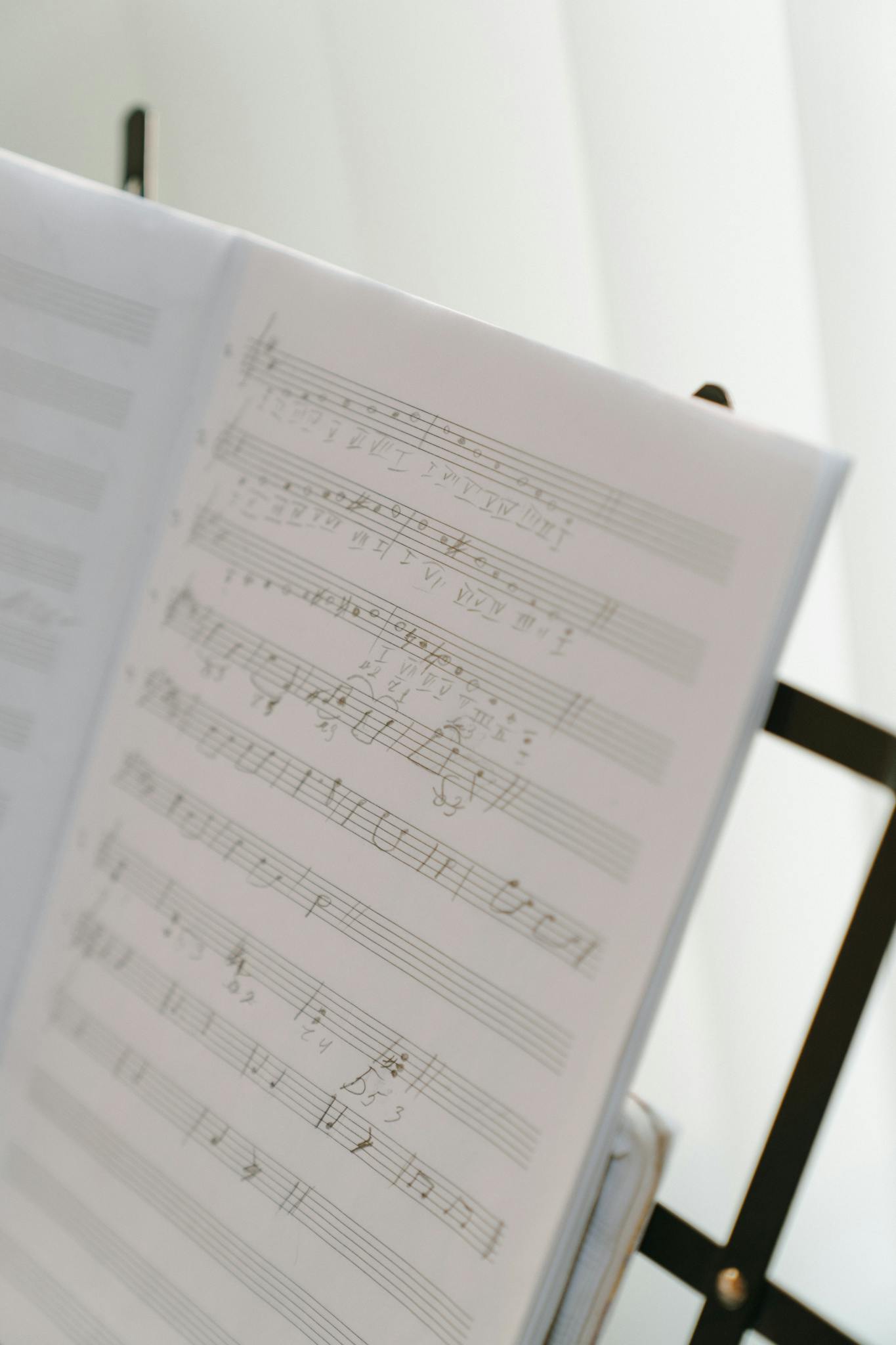 A soft-focused image of sheet music on a music stand with natural light.